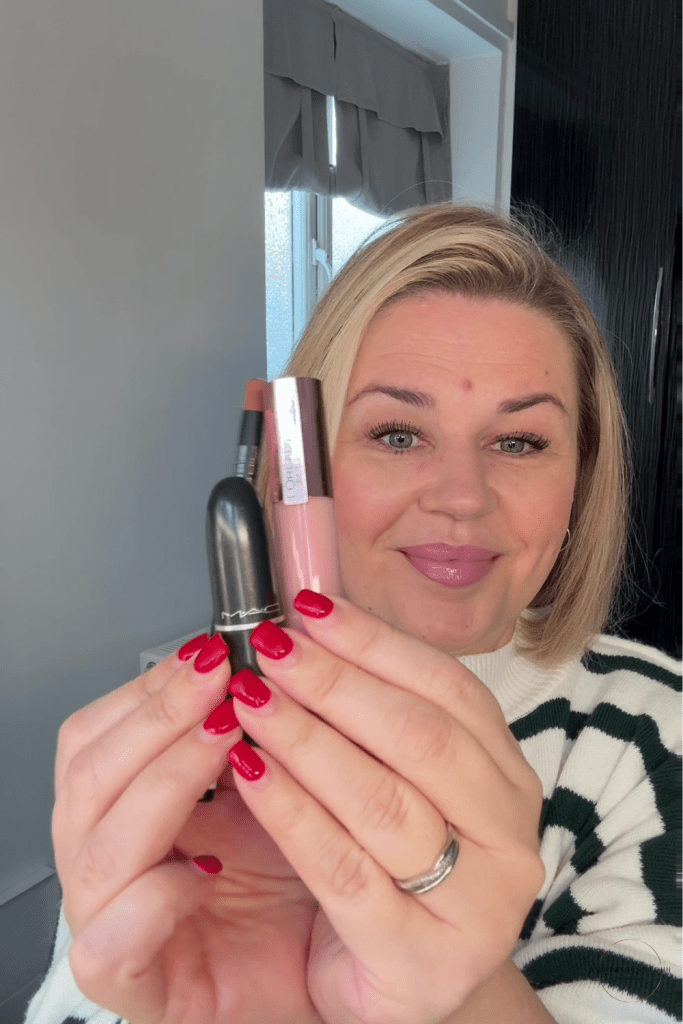 pink‑toned nude lip combo, including a MAC pink‑nude lipstick, a brown Rimmel Cappuccino lip liner, and the L’Oréal Lifter Gloss in the shade Soar. soft natural light, showing the tones clearly — a cool‑leaning pink lipstick, a warm brown liner for definition, and a milky pink gloss that gives a smooth, blurred finish