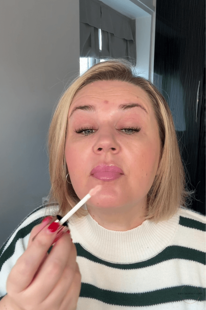 pink‑toned nude lip combo, including a MAC pink‑nude lipstick, a brown Rimmel Cappuccino lip liner, and the L’Oréal Lifter Gloss in the shade Soar. soft natural light, showing the tones clearly — a cool‑leaning pink lipstick, a warm brown liner for definition, and a milky pink gloss that gives a smooth, blurred finish