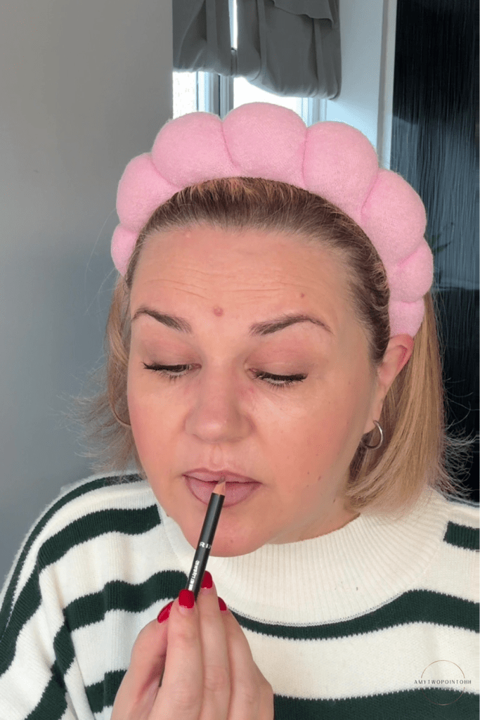 pink‑toned nude lip combo, including a MAC pink‑nude lipstick, a brown Rimmel Cappuccino lip liner, and the L’Oréal Lifter Gloss in the shade Soar. soft natural light, showing the tones clearly — a cool‑leaning pink lipstick, a warm brown liner for definition, and a milky pink gloss that gives a smooth, blurred finish